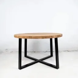 Okrągły stolik kawowy z jasnego drewna na czarnych, metalowych nogach w kształcie litery X. Minimalistyczny design na tle białej ściany.