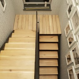 CLIC HOUSE WOOD - Jasne, drewniane schody z barierką, widziane z góry, z dekoracyjną ścianą w tle. Uwagę zwracają drewniane pokrywy nad częścią schodów.