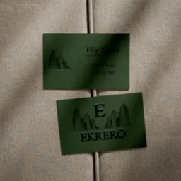 Dwie zielone wizytówki z czarnym nadrukiem na beżowym tle. Górna wizytówka z imieniem i nazwiskiem Filip Nowak, dolna z logo EKREO i motywem budynków.