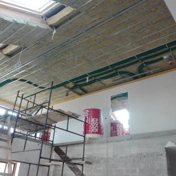 NOVUM-INSTAL - Ocieplenie poddasza wełną mineralną w Tuszowie Narodowym. Widoczne rury wentylacyjne, ruszt pod płyty GK i pakiety wełny Rockwool Super.