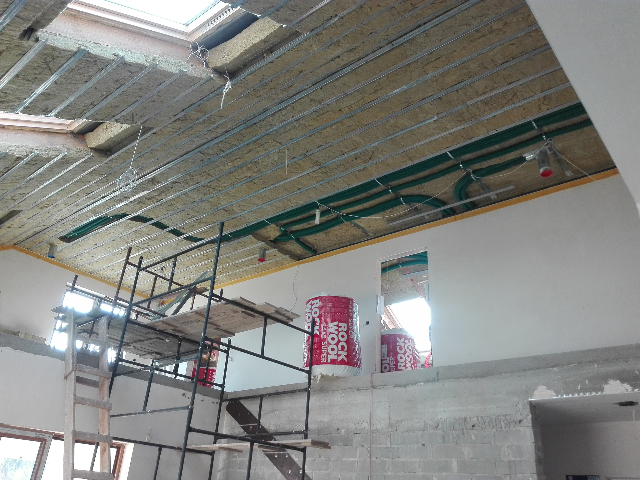 Ocieplenie poddasza wełną mineralną w Tuszowie Narodowym. Widoczne rury wentylacyjne, ruszt pod płyty GK i pakiety wełny Rockwool Super.