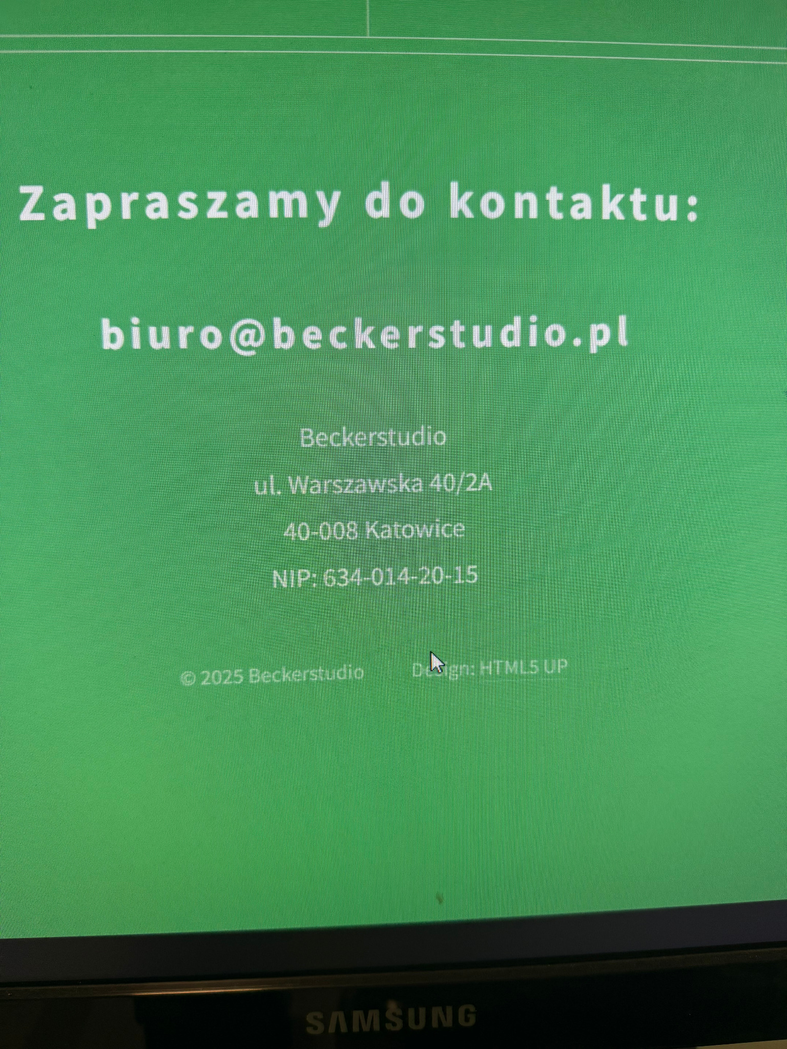 Zielony ekran monitora z danymi kontaktowymi: adresem e-mail, adresem firmy Beckerstudio w Katowicach i numerem NIP. Widoczny kursor myszy.