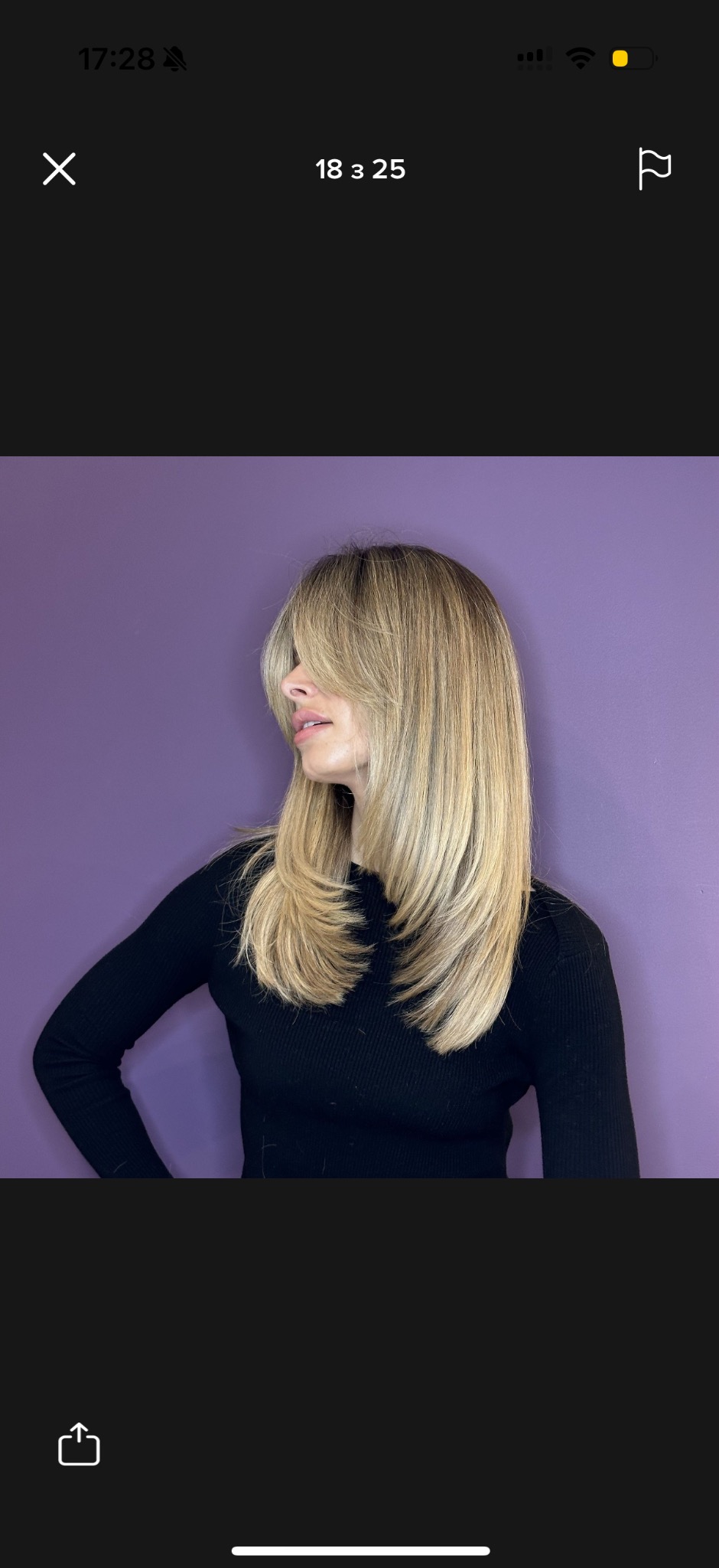 Profil kobiety z blond włosami z grzywką, na fioletowym tle. Włosy są proste i sięgają do ramion. Ubrana w czarny sweter z długim rękawem.