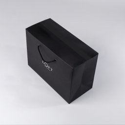 Fot. produktowa ekskluzywnej torby prezentowej LOFT. 
Minimalistyczne ujęcie w lekkiej perspektywie z góry. 
Miękkie oświetlenie podkreśla matową powierzchnię torby. Kompozycja w stylu premium – idealna do katalogów lub materiałów reklamowych marki.