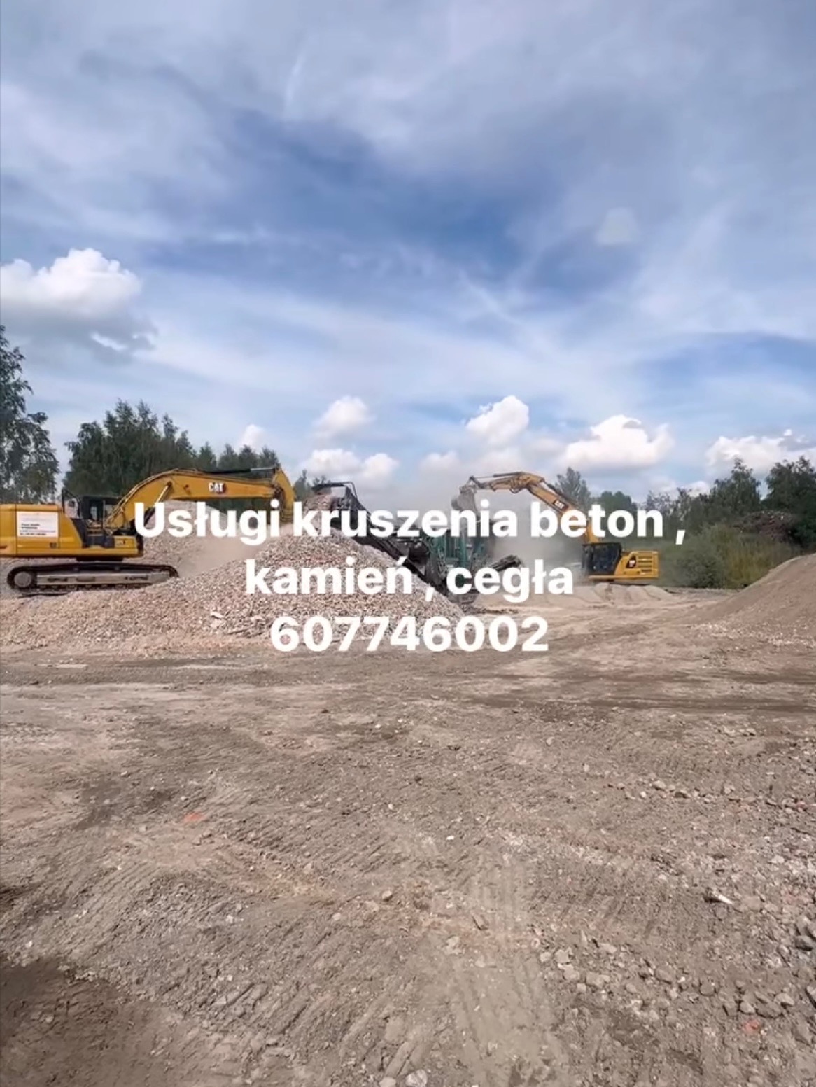 Kruszenie gruzu budowlanego przez żółte koparki CAT. W tle drzewa i pochmurne niebo. Widoczne kruszywo i numer telefonu do kontaktu.