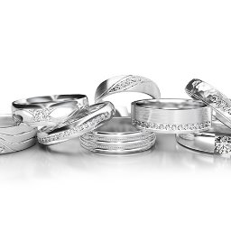 AMORO SPÓŁKA Z OGRANICZONĄ ODPOWIEDZIALNOŚCIĄ - Eleganckie, srebrne obrączki z różnymi wzorami i kamieniami, ułożone na białym tle, idealne na prezent.