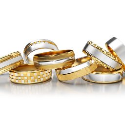 AMORO SPÓŁKA Z OGRANICZONĄ ODPOWIEDZIALNOŚCIĄ - Zestaw siedmiu eleganckich obrączek ślubnych z białego i żółtego złota, o różnych wzorach i wykończeniach, ułożonych na błyszczącej powierzchni w jasnym oświetleniu.