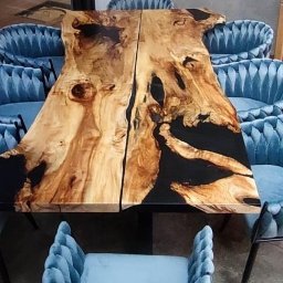 Drewniane Klimaty - Stół z dwuczęściowego blatu z żywicą epoksydową, otoczony błękitnymi krzesłami w stylu glamour. Blat z naturalnego drewna o nieregularnych krawędziach.