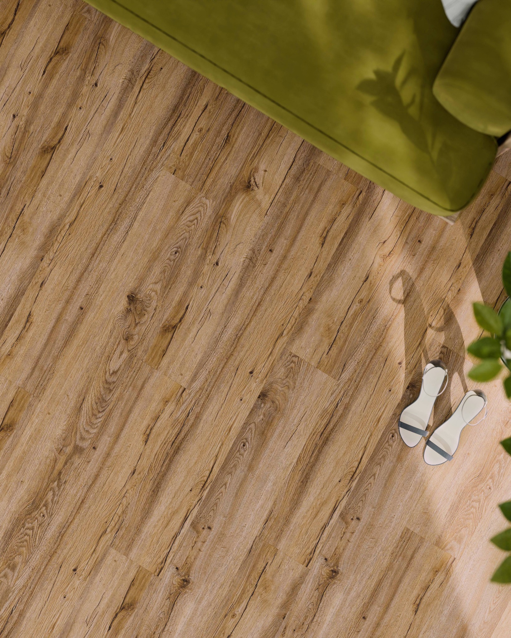 Ułożona pod kątem, jasnobrązowa powierzchnia z wyraźnym rysunkiem drewna, uzupełniona fragmentem sofy i butami w rogu, oświetlona naturalnym światłem.