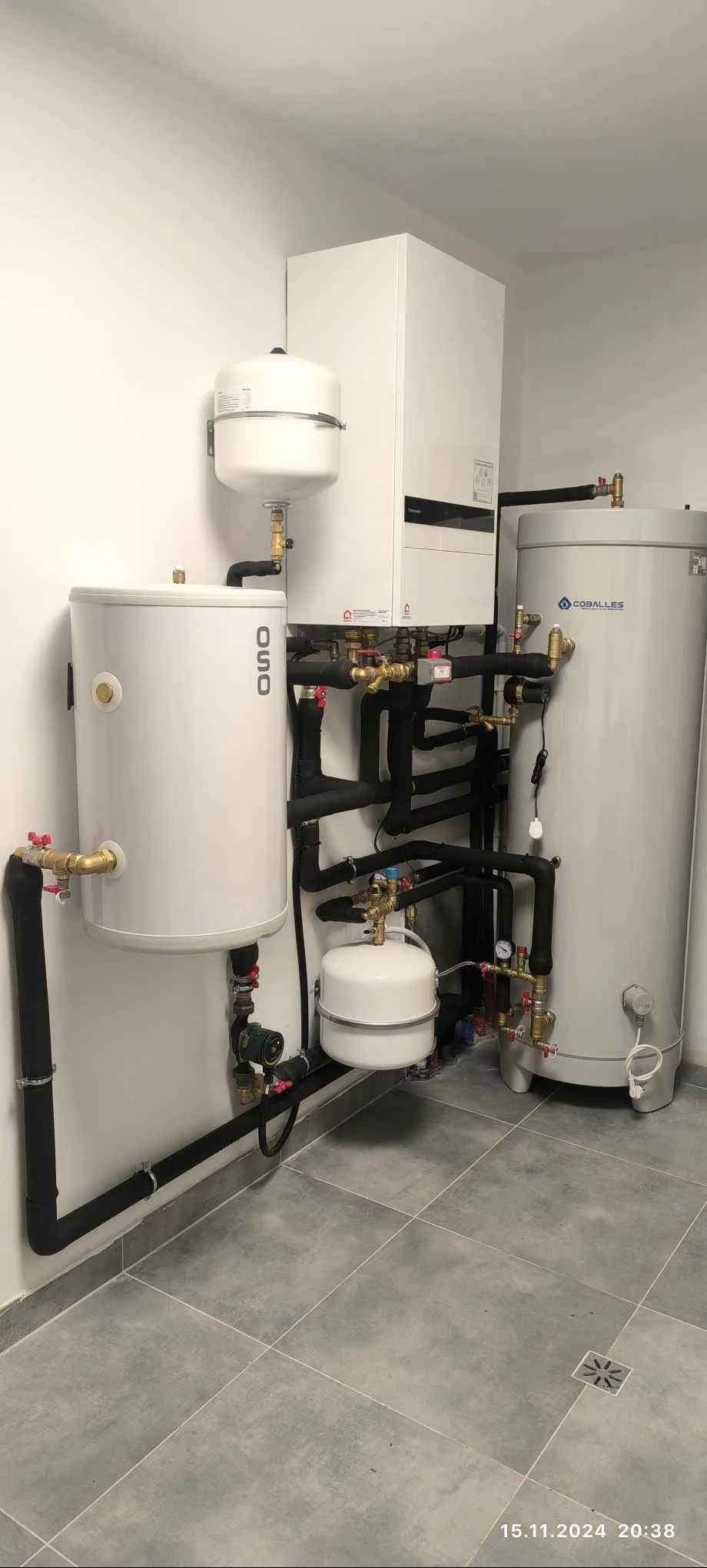 Złożona instalacja grzewcza z zbiornikami OSO i Coballes we Wrocławiu. Rury w izolacji, zawory i manometry. Nowoczesne kotły grzewcze w jasnym pomieszczeniu.