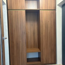 STOLARSTWO - Nowoczesna szafa wnękowa z forniru orzechowego, z otwartymi półkami i złotymi akcentami, dopasowana do marmurowej podłogi. Minimalistyczny design.