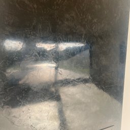 Zakład Remontowo Budowlany ART-DOM Dariusz Sajnóg - Ściana z efektem dekoracyjnym w odcieniach szarości i srebra, imitująca metaliczne wykończenie. Widoczna faktura i refleksy świetlne. Fragment obudowy kominka.