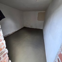 MIKO Erwin Mikołajczyk - Wnętrze w trakcie wylewki podłogi, ściany przygotowane pod malowanie. Widoczne fragmenty ceglanej konstrukcji. Surowy stan wykończenia.
