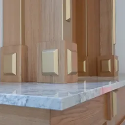 Detal drewnianej zabudowy z marmurowym blatem, złote akcenty, widoczne szafki. Starannie wykonane elementy dekoracyjne.