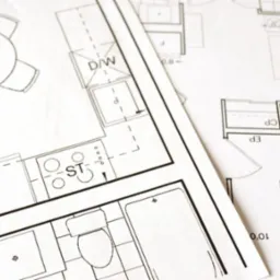 Fragment planu architektonicznego z detalami kuchni, łazienki i salonu. Widoczne oznaczenia wymiarów i wyposażenia.