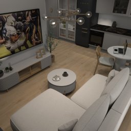 Sedno Przestrzeni Anna Sułot - Wnętrze mieszkania z sofą modułową, telewizorem z dynamicznym obrazem, okrągłym stolikiem kawowym i jadalnianym. Jasna kolorystyka, drewniana podłoga.