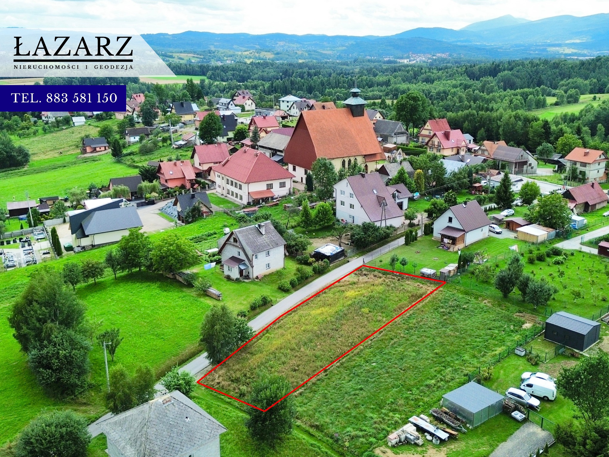 Działka budowlana z wyraźnie zaznaczonymi granicami na tle malowniczego krajobrazu, widok z lotu ptaka, domy, zieleń, góry w oddali. Logo firmy w lewym górnym rogu.