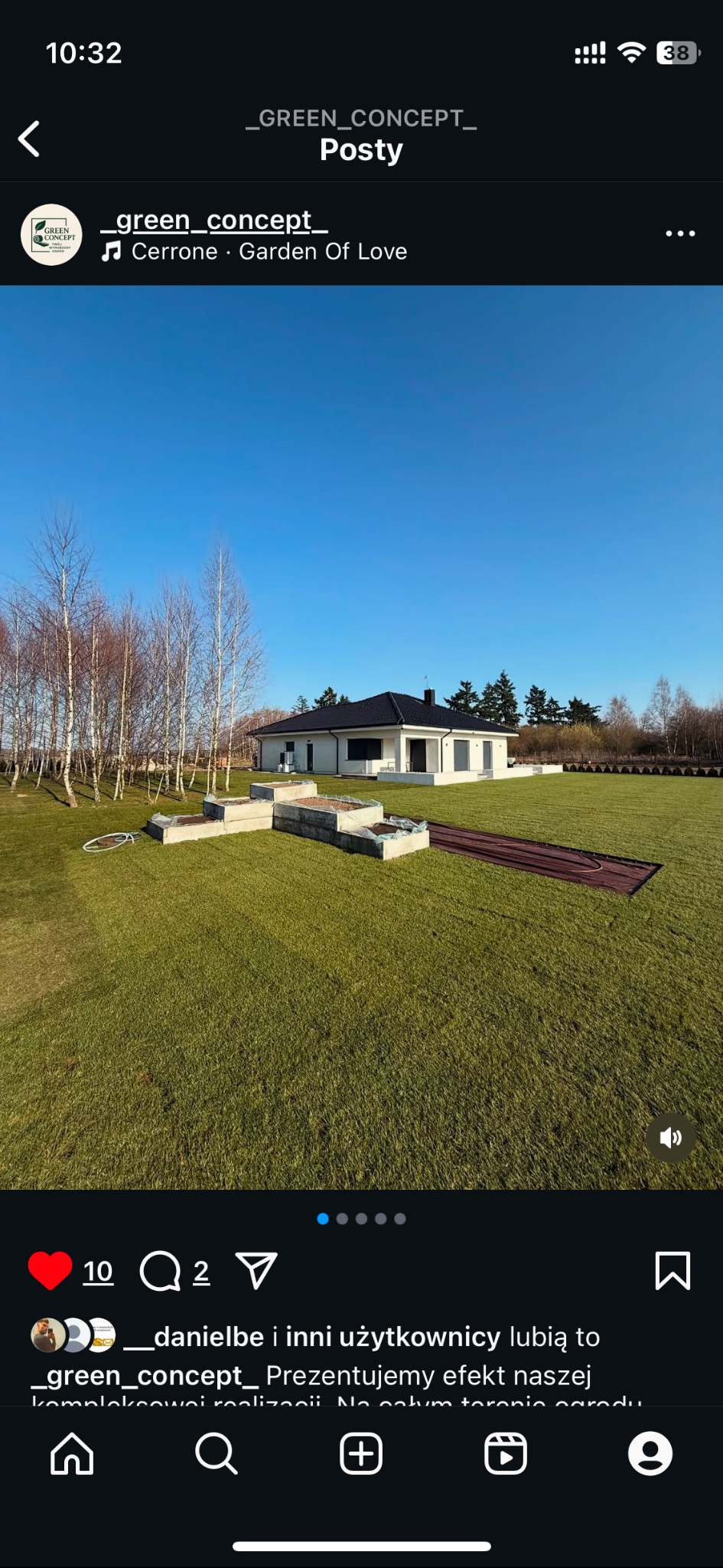 Nowoczesny dom z zadbanym trawnikiem, betonowe rabaty i rozłożony system nawadniania. Widok na ogród w słoneczny dzień z perspektywy ziemi.