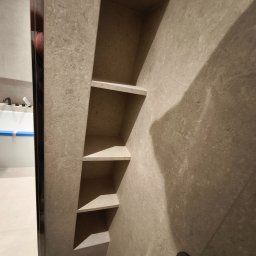 Pomalowany Wrocław - Półki wnękowe z płytek w łazience we Wrocławiu. Widoczna wanna z czarną armaturą. Wykończenie w jasnych, beżowych odcieniach.