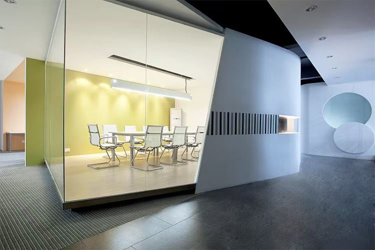 Szklane drzwi oddzielają salę konferencyjną z białym stołem i krzesłami od korytarza z dekoracyjnymi okręgami. Minimalistyczny design, nowoczesne oświetlenie.