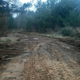 RTD Radosław Trzebiatowski - Utrudniona droga gruntowa po pracach ziemnych, ślady opon w błocie, widok na las w tle. Częściowo niwelacja terenu.