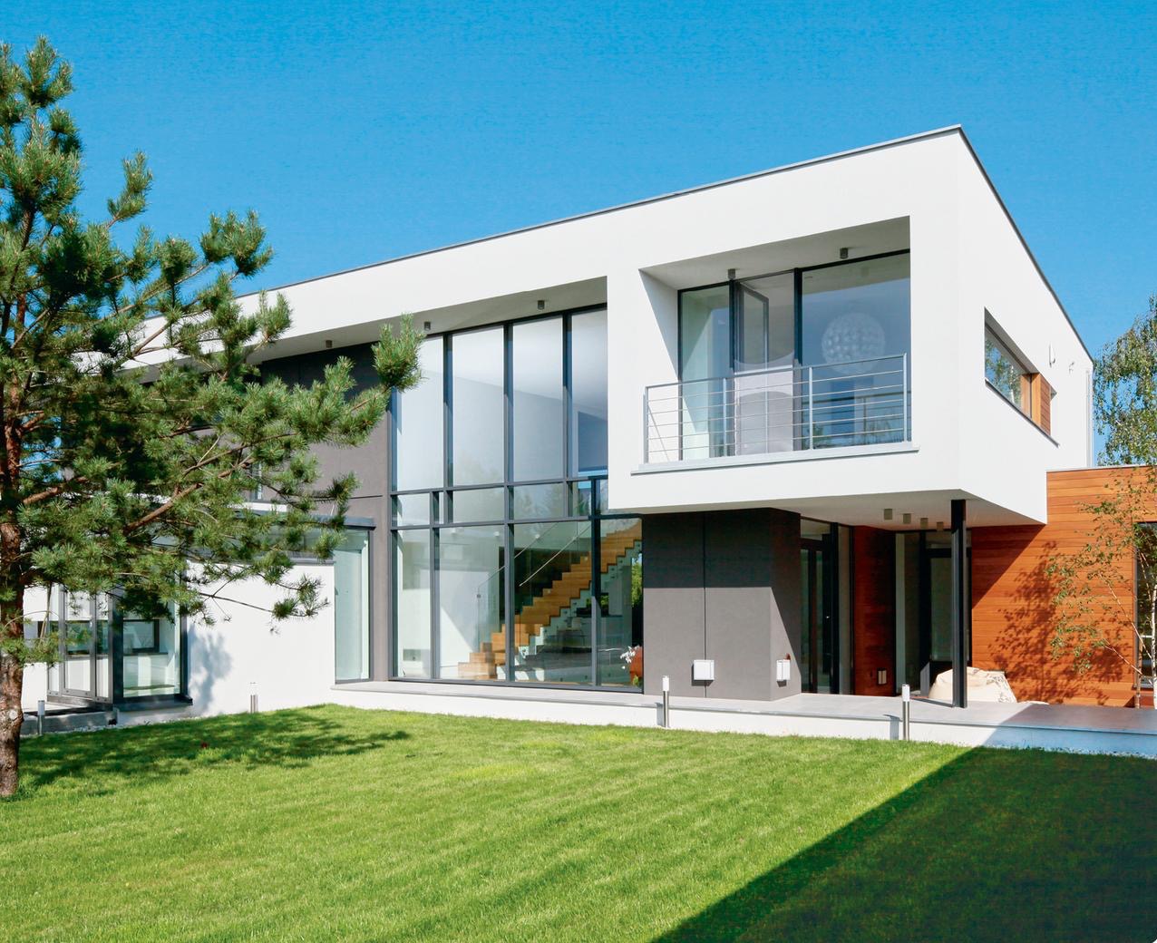 Nowoczesny dom z dużymi przeszkleniami i drewnianymi elementami elewacji, jasne tło nieba, widok z zewnątrz na schody wewnątrz.