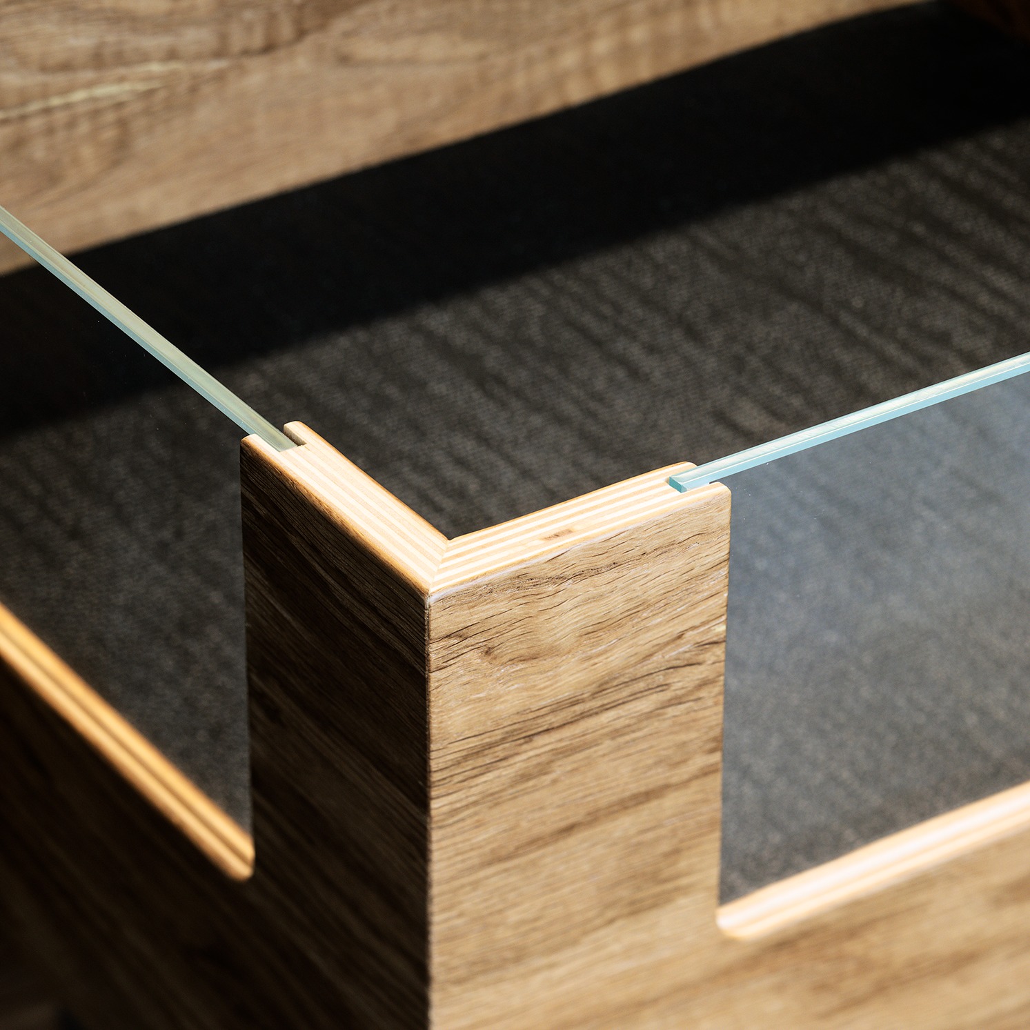 Szczegół narożnika drewnianej konstrukcji z elementami szkła, nowoczesny design mebla w Leoncin. Minimalistyczne wykończenie i precyzja wykonania.