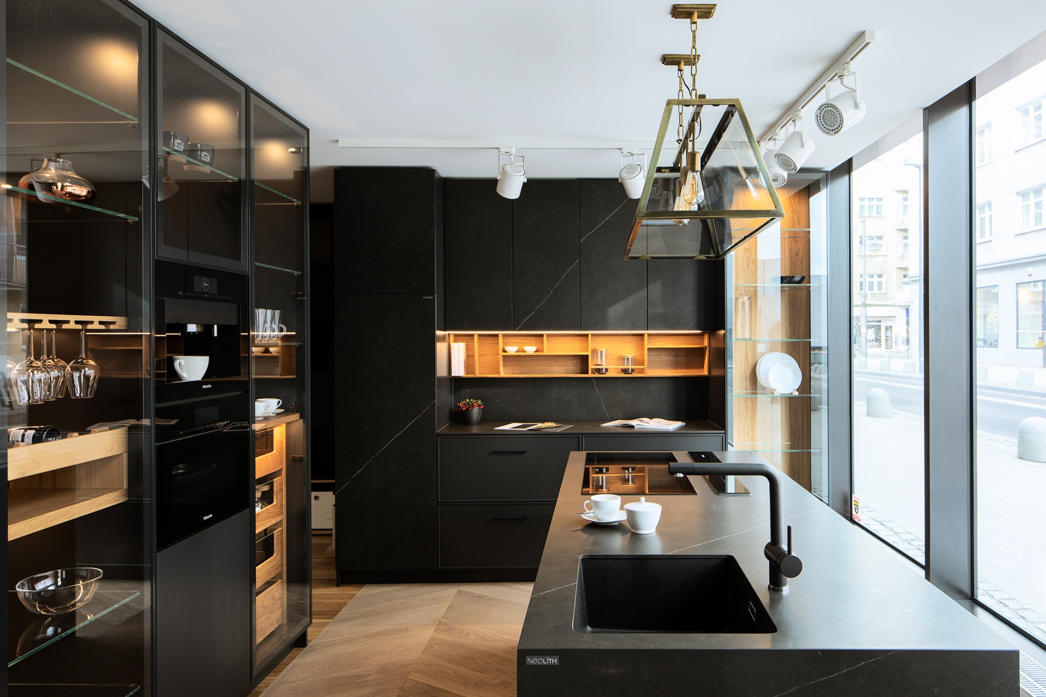 Elegancka, czarna kuchnia z oświetleniem LED, drewnianymi akcentami i dużym oknem z widokiem na ulicę. Nowoczesny design z dbałością o detale.