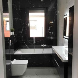 Dawid andraczek - Elegancka łazienka po remoncie: czarne marmurowe płytki na ścianach, biała armatura i podłoga z jasnego marmuru. Nowoczesne oświetlenie i minimalistyczny design.