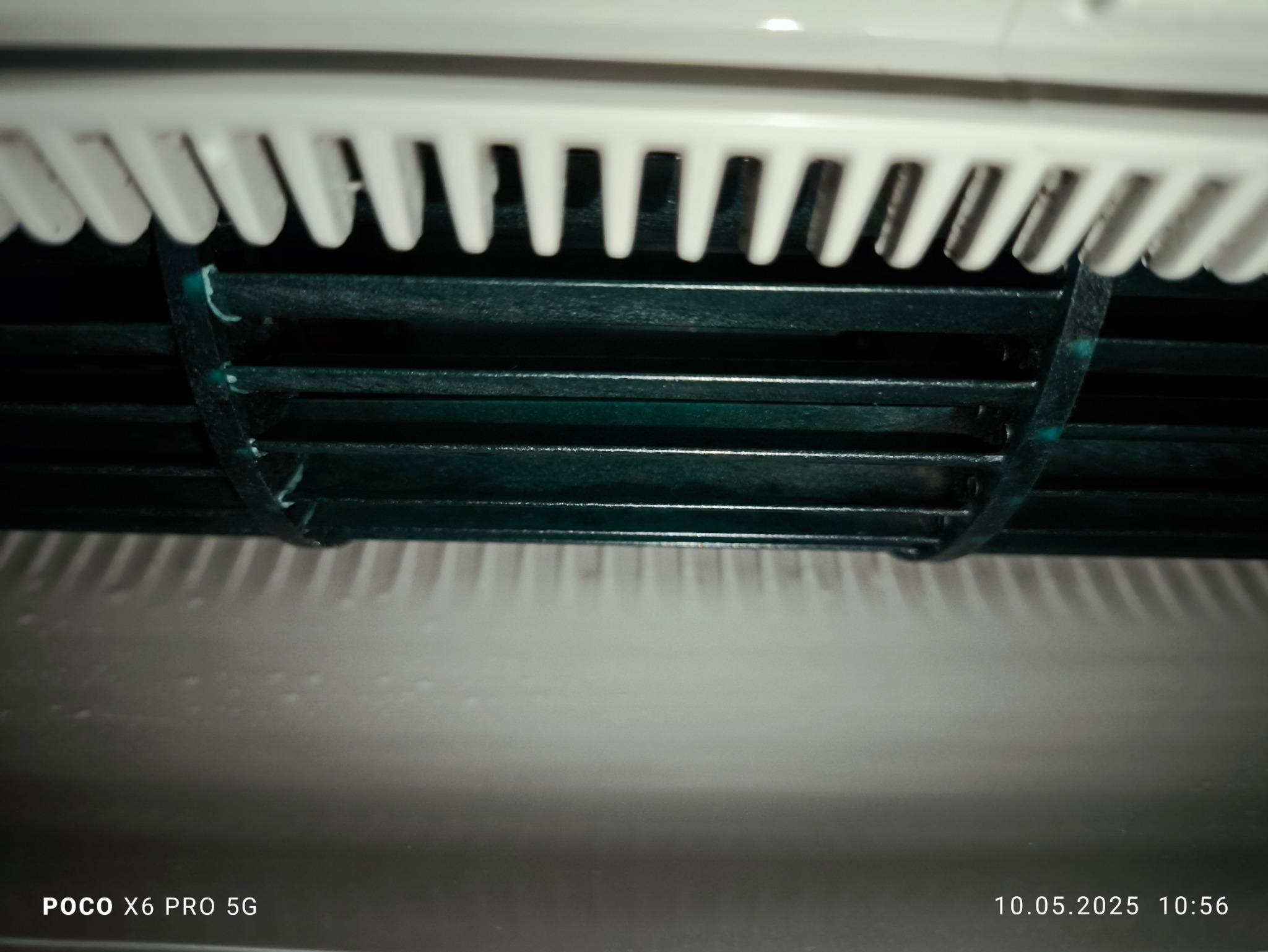 Szczegółowe ujęcie filtra klimatyzacji, z widocznymi lamelami i elementami konstrukcyjnymi. Filtr jest lekko zakurzony, co sugeruje potrzebę serwisu.