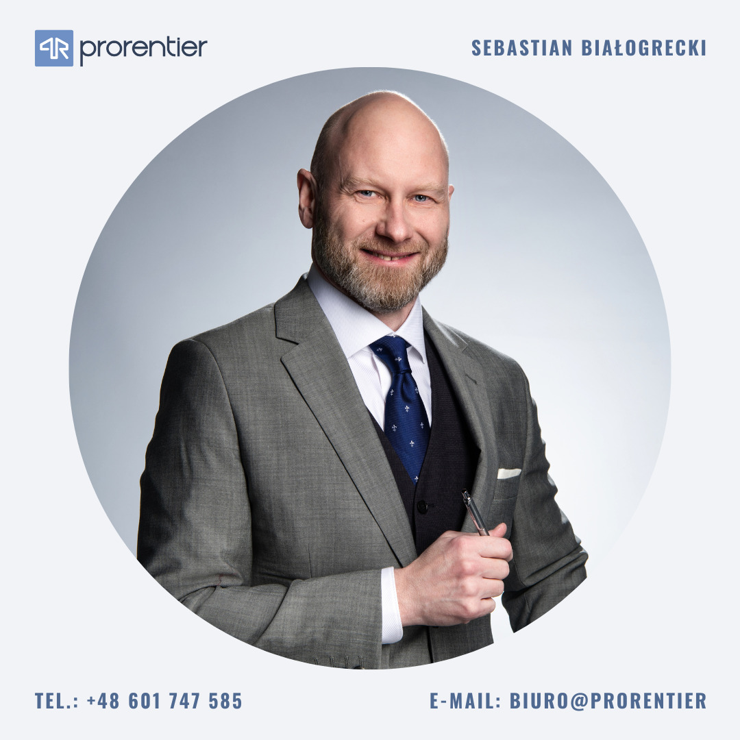 Portret agenta nieruchomości Sebastian Białogrecki w garniturze, z uśmiechem i długopisem w dłoni, na jasnym tle w okręgu z logo 'prorentier' u góry.