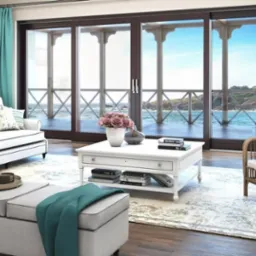 Salon z dużymi, przesuwnymi drzwiami balkonowymi z widokiem na morze. Turkusowe zasłony i jasne meble tworzą przytulną atmosferę.