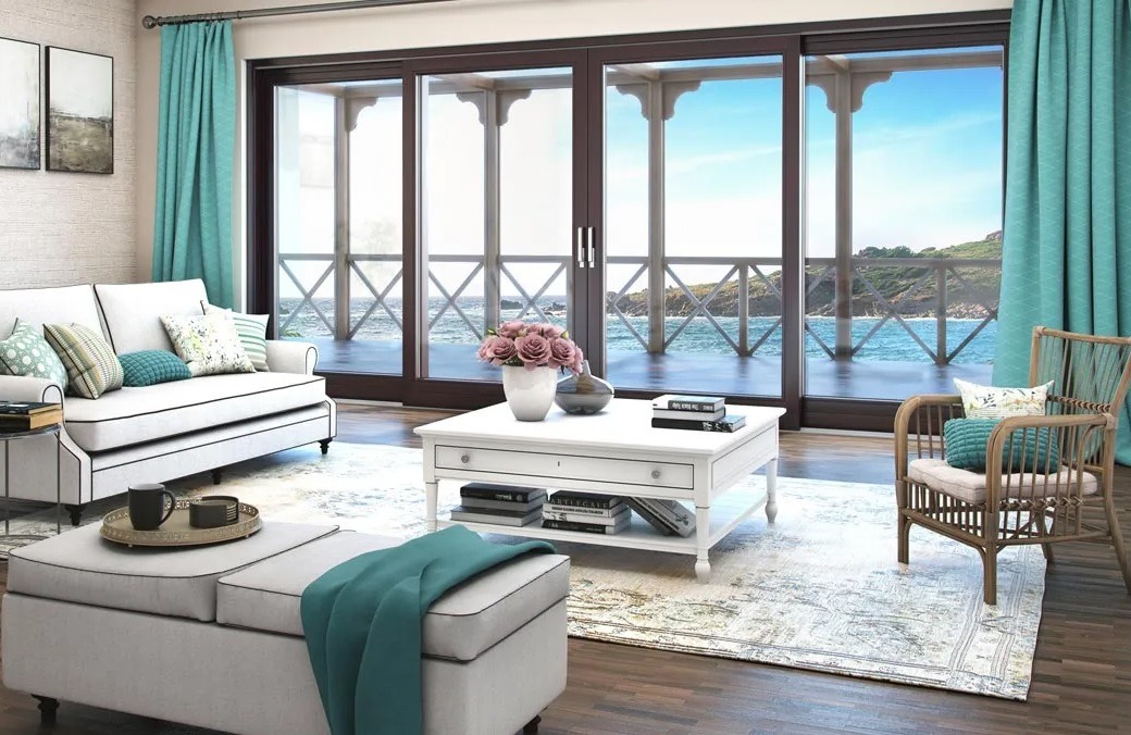 Salon z dużymi, przesuwnymi drzwiami balkonowymi z widokiem na morze. Turkusowe zasłony i jasne meble tworzą przytulną atmosferę.