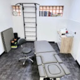 Barteczko Fizjoterapia Mysłowice - Rehabilitacja - Terapia Manualna - Osteopatia - Nowoczesny gabinet rehabilitacyjny w Mysłowicach. Profesjonalny stół do masażu, drabinki gimnastyczne, krzesło obrotowe i szafka medyczna. Jasne wnętrze.