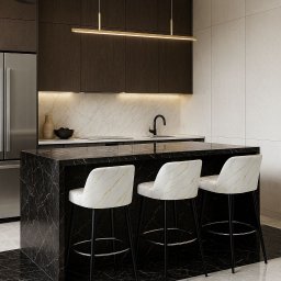 Edite Meble - Nowoczesna kuchnia z wyspą wykończoną czarnym marmurem i trzema hokerami barowymi z welurowymi siedziskami w odcieniach bieli i złota. Minimalistyczne oświetlenie.