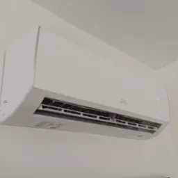 Biała klimatyzacja marki CH zamontowana na ścianie w pomieszczeniu. Widoczny wyświetlacz temperatury i logo. Minimalistyczny design.