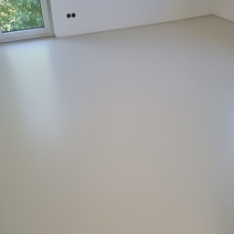 DAWID SZWAGIEL LEITO FLOORS - Jasna, jednolita posadzka w nowym wnętrzu. Świeżo wylana, gładka powierzchnia w surowym stanie, widoczne ślady po szalunku na ścianach. Minimalistyczny design.