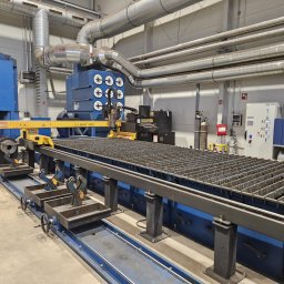 ZOK-TECH - Plasma CNC: precyzyjne cięcie metalu na stole z rusztem, system odciągowy, przemysłowy design, detale obróbki skrawaniem.