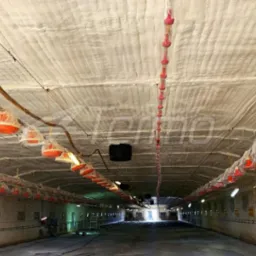 Poddasze budynku gospodarczego po natrysku pianką PUR; widoczne elementy wyposażenia zabezpieczone folią, równomierna struktura izolacji na całej powierzchni.