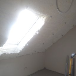 Sigma Pur - Poddasze z oknem dachowym po aplikacji pianki PUR, widoczne narzędzia pracy. Biała izolacja szczelnie wypełnia przestrzeń wokół okna, tworząc jednolitą warstwę.