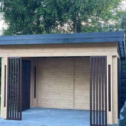 WOODCRAFTER ARTEM ZHYRNOV - Drewniana altana z płaskim dachem i ażurowymi panelami wejściowymi, na tle zielonego trawnika i drzew. Widok z przodu, stonowana kolorystyka.