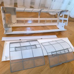BessCool Klimatyzacja - Rozłożony panel klimatyzatora z filtrami na parkiecie, gotowy do czyszczenia lub serwisu. Widoczne elementy obudowy i filtry powietrza.