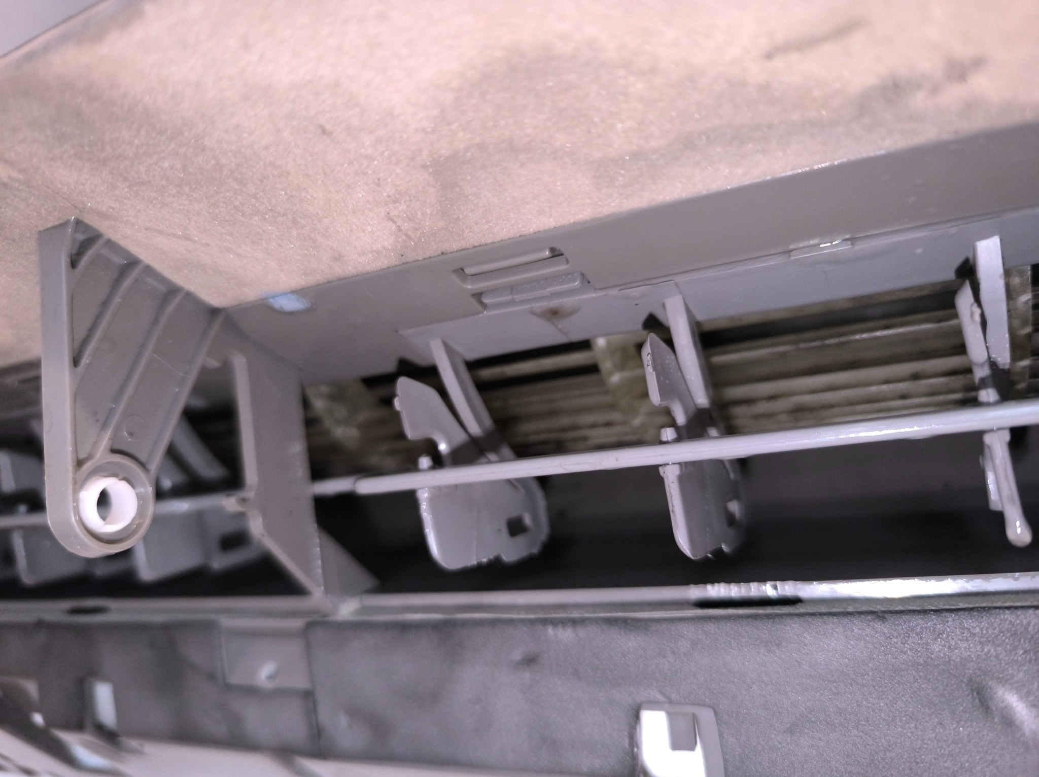 Szczegółowe ujęcie wnętrza klimatyzatora z widocznymi elementami regulacji przepływu powietrza, ukazujące konstrukcję i mechanizm działania urządzenia.