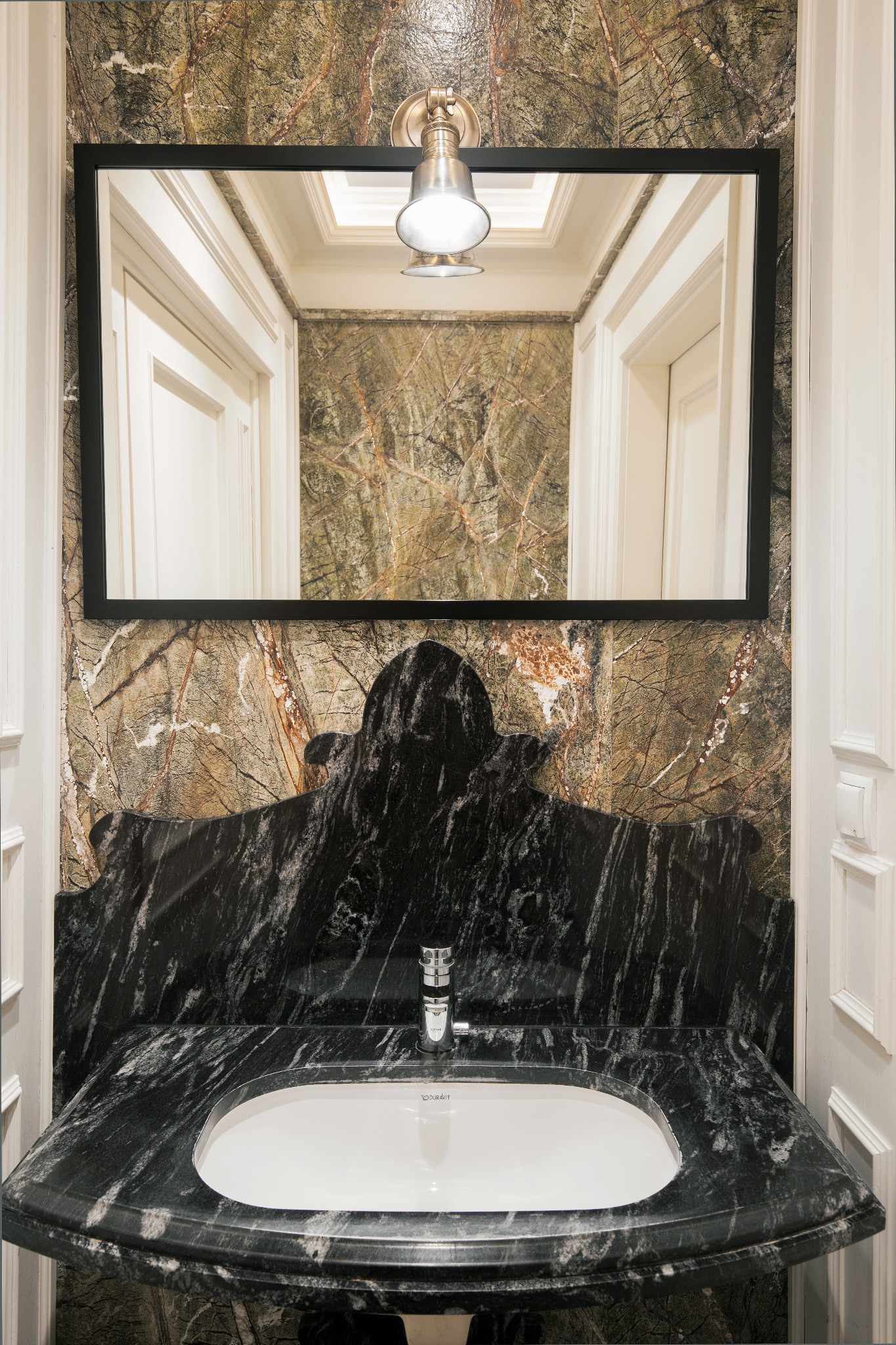 Ekskluzywna łazienka z blatem z zielonego marmuru Forest Green, umywalką Duravit i lustrem w czarnej ramie. Nietypowe wykończenie ścian i oświetlenie punktowe.