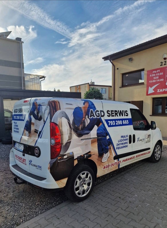 Biały samochód dostawczy z reklamą serwisu AGD, na którym widnieje numer telefonu, nazwa firmy i lista naprawianych urządzeń: pralki, lodówki, zmywarki, piekarniki.