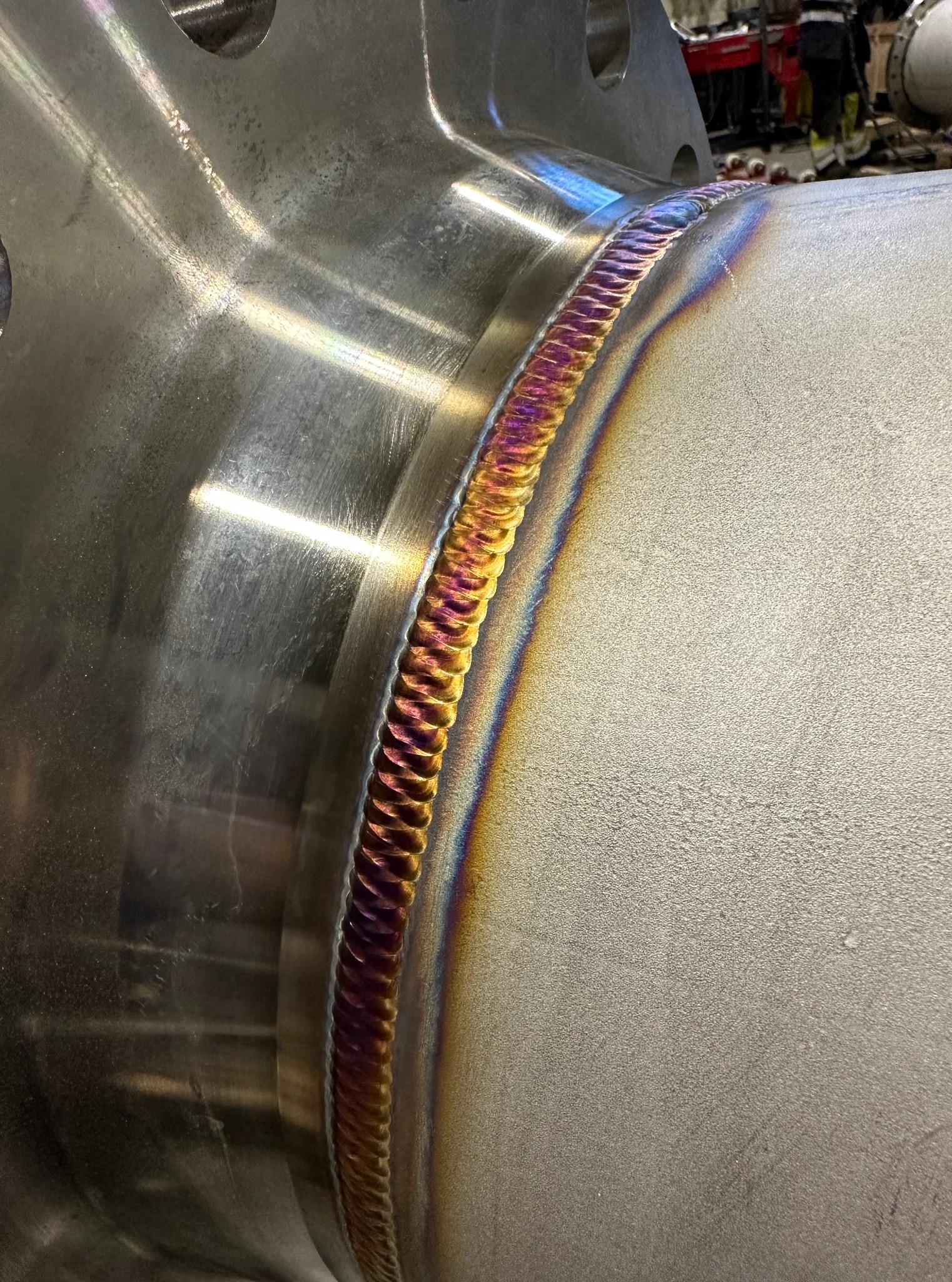 Spoina TIG na rurze ze stali nierdzewnej z widocznymi kolorami utleniania, wskazującymi na wysoką jakość wykonania i precyzję spawania.