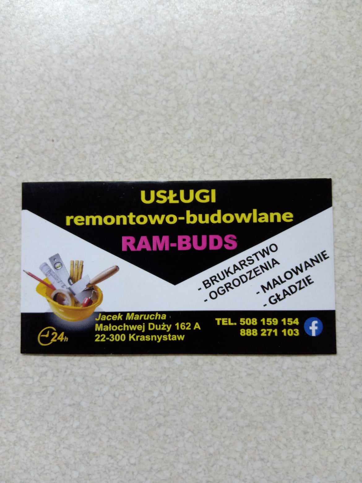 Wizytówka firmy remontowo-budowlanej RAM-BUDS z narzędziami w żółtym wiaderku, oferującej brukarstwo, ogrodzenia, malowanie i gładzie, z danymi kontaktowymi.