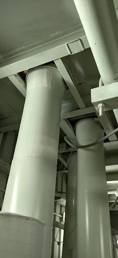 Wnętrze hali z widocznymi stalowymi, pomalowanymi na szaro kolumnami wspierającymi konstrukcję dachu. Widoczne połączenia spawane.