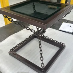 Metalowy stolik kawowy z szklanym blatem i łańcuchami w Tarnowie. Nietypowa konstrukcja spawana, nowoczesny design. Idealny do industrialnego wnętrza.