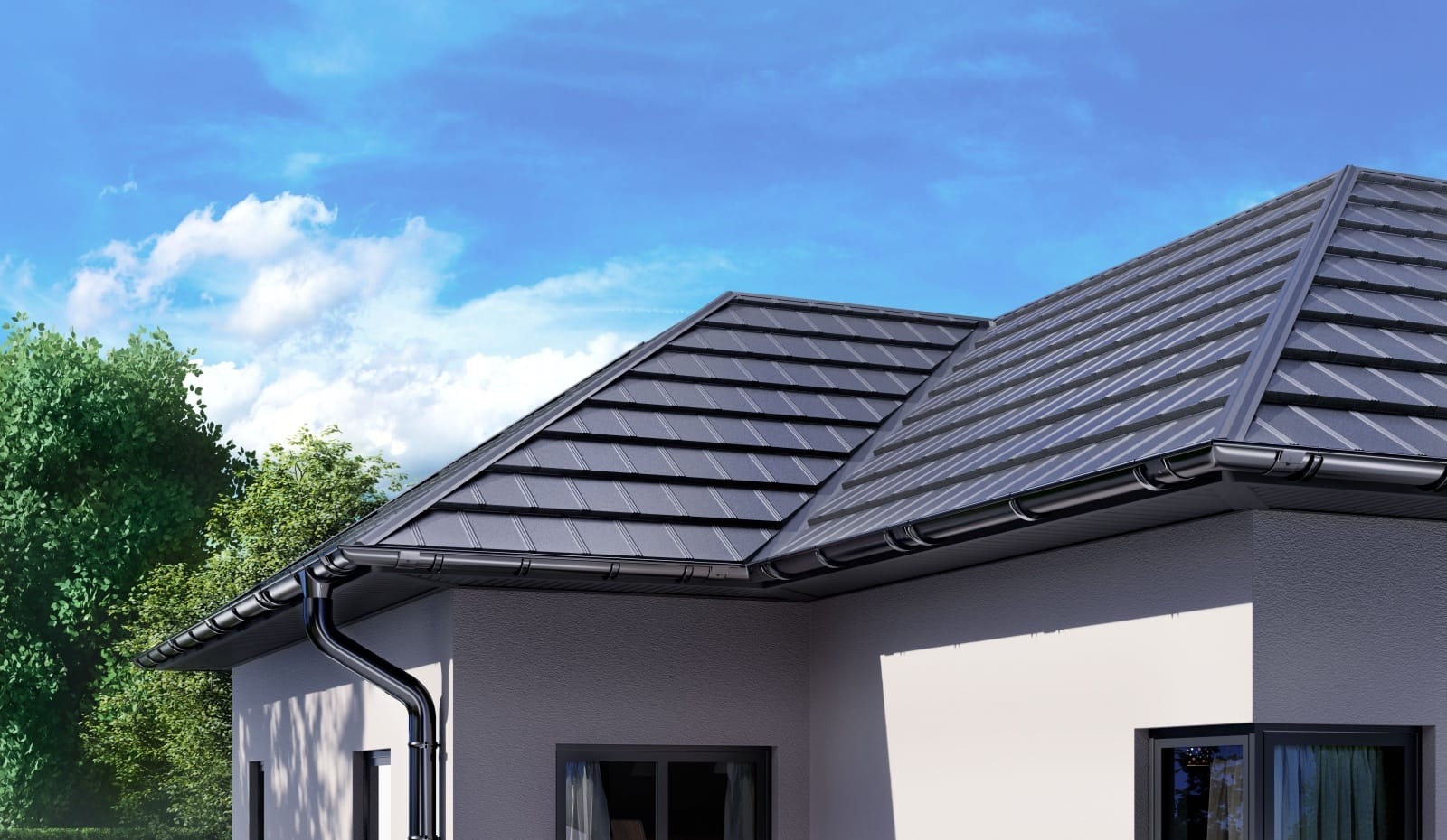 Nowoczesny dom z grafitowym dachem z blachy i systemem rynnowym w kolorze, na tle błękitnego nieba i zieleni. Widok z dołu, podkreślający geometrię dachu.
